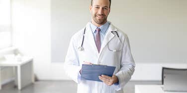 doctor holding chart standing in the middle of office