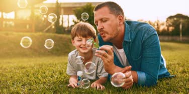 dad blowing bubbles with son