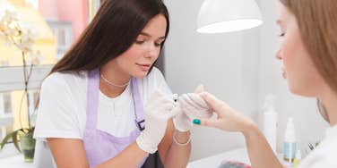 female nail technician doing female client's nails