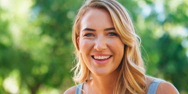 Smiling happy woman outside in the sunshine