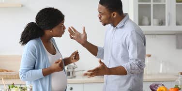 pregnant wife and husband arguing while she cooks dinner