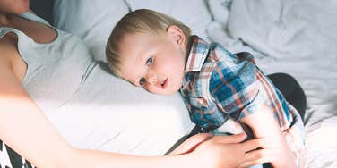 toddler resting on mom's pregnant belly 