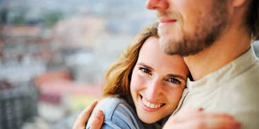 Woman hugging man, smiling outdoors opening up emotionally in a relationship 