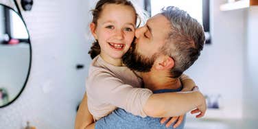 Parent Hugging child, teaching her how to become a very calm adult. 