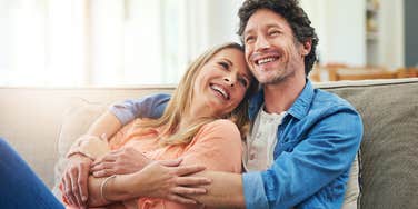 good husband hugging wife on couch