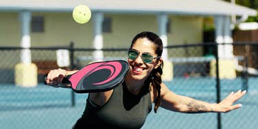 Woman playing pickleball with partner.