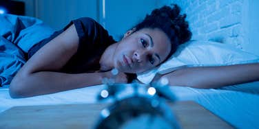 Woman who can't fall asleep because of racing thoughts