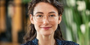 smiling woman with glasses wearing a polka dot shirt