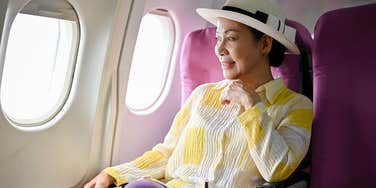 woman sitting in first class window seat on plane