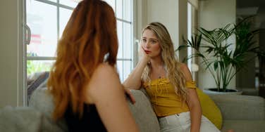 two unhappy women signs someone holding grudge