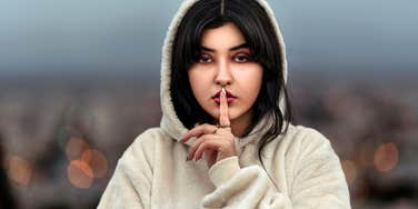 Woman in hoodie keeping secrets giving excuses for cheating