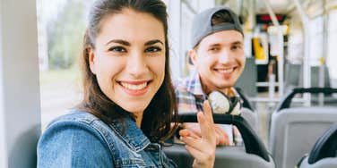 woman sits on the bus with her husband smiling