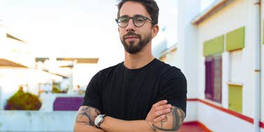 Angry man standing in apartment building calm because of his woman