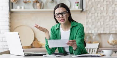 Woman who is experiencing lifestyle creep looking at her bank statement