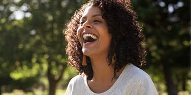 Woman smiling and laughing outside.