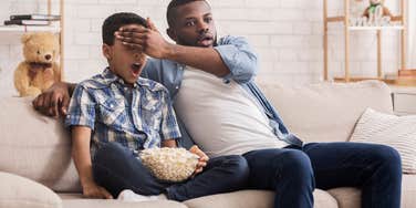 Dad blocking his kid's eyes from seeing a movie