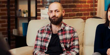 Bald man in office looking sad, doesn't fully trust his partner