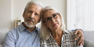 serious boomer couple looking unhappy