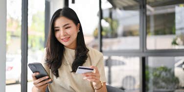 financially successful woman holding her credit card