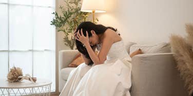 upset bride sitting with head in hands