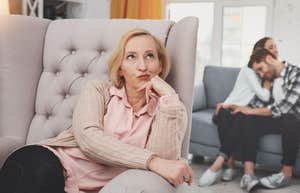 mother in law sits in armchair while son gets support from wife