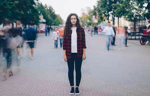 woman stands isolated in bustling crowd of people
