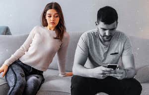 Woman peeking over at partners phone, trust issues 
