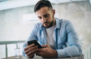 Man looking bored while watching short-form content on phone. 