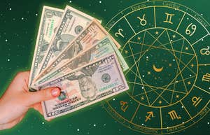 hand with money on zodiac wheel