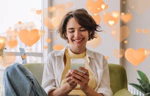Woman with short brown hair smiling at the text message that means the most to her