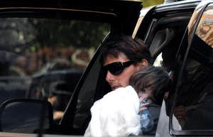 Tom Cruise carrying baby Suri out of a car