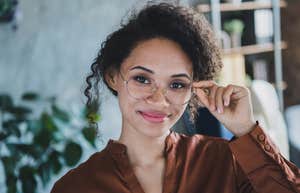 consistent determined woman fixing glasses