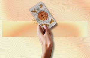 hand holding tarot card for weekly horoscope june 24 - 30