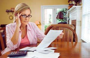woman sitting at table paying monthly bills