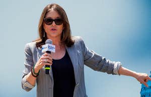 Marianne Williamson, holding a mic, leaving the campaign for president