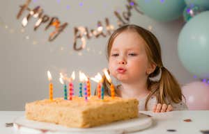 little girl blowing out birthday candles