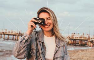 Happy woman, taking a photo with her camera