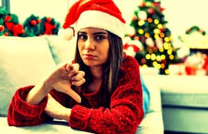 woman in Santa hat giving thumbs down