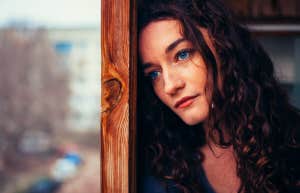 beautiful sad lonely girl sitting near the window is missing